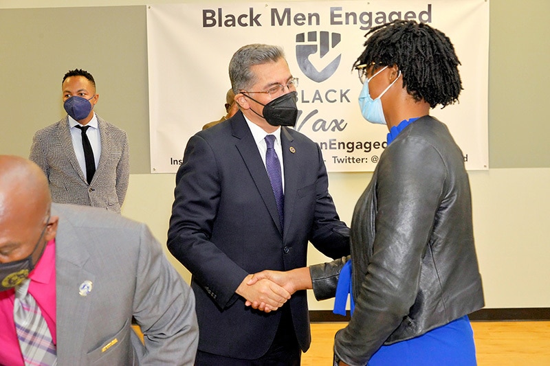 HHS Secretary Becerra shakes hands with a community leader at the Black Men Engaged roundtable