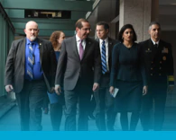 A group of people in suits walking down a hallway