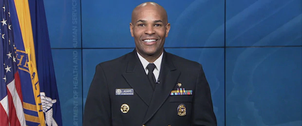 U.S. Surgeon General, VADM Jerome Adams in uniform centered in front of blue background.