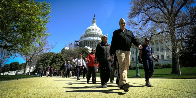 HHS staff walk by the U.S. Capitol.