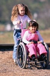 A girl pushes another girl in a wheelchair