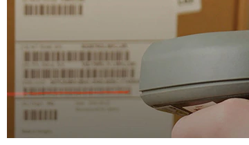  A scanner scanning the label on the side of a box.