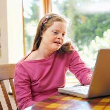 A special education child works on a laptop.