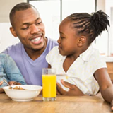 father with young child enjoying breakfast