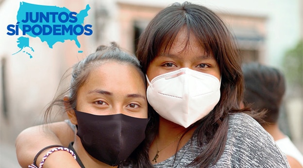Two young people wearing masks embrace and look at the camera. There is an emblem reading 'Juntos Si Podemos' in the upper left corner.