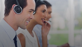 A row of phone diverse operators speaking into headsets.