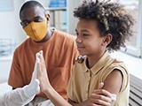 boy high fiving doctor after getting vaccinated