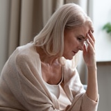 Sad mature woman sitting alone at home alone