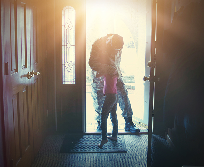 Papá militar regresa a casa y abraza a su hija en la puerta